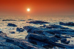 Bright orange sun over the sea and rocky shore. royalty free stock image Bright orange sun over the sea and rocky shore. royalty free stock image