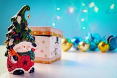 Bright toy dwarf with a cheerful face and a bell on the cap shiny balls, box on white background. stock images Bright toy dwarf with a cheerful face and a bell on the cap shiny balls, box on white background. stock images