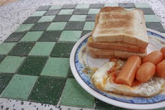 Brinde o café da manhã com ovos fritos e salsichas na tabela de pedra fotografia de stock Brinde o café da manhã com ovos fritos e salsichas na tabela de pedra fotografia de stock