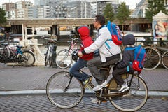 Bringen Sie zwei Kinder auf dem Fahrrad auf einmal tragen hervor Amsterdam, die Niederlande lizenzfreie stockfotografie Bringen Sie zwei Kinder auf dem Fahrrad auf einmal tragen hervor Amsterdam, die Niederlande lizenzfreie stockfotografie