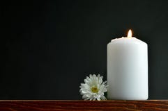Brinnande stearinljus och vit blomma arkivbild Brinnande stearinljus och vit blomma arkivbild