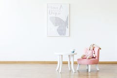 Brinquedo do luxuoso na cadeira cor-de-rosa na tabela na sala branca w interior do ` s da menina fotos de stock Brinquedo do luxuoso na cadeira cor-de-rosa na tabela na sala branca w interior do ` s da menina fotos de stock