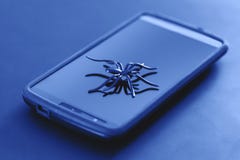 Brinquedo plástico da aranha na ação da corrida na superfície do telefone celular fotos de stock Brinquedo plástico da aranha na ação da corrida na superfície do telefone celular fotos de stock