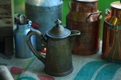 Brocche antiche del metallo e bidoni di latte di alluminio e di rame sulla tovaglia di tela fotografia stock libera da diritti Brocche antiche del metallo e bidoni di latte di alluminio e di rame sulla tovaglia di tela fotografia stock libera da diritti