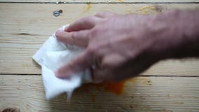 Broken fresh eggs on floor and hand wiping it off