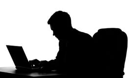 Broker silhouette typing on laptop computer, sending e-mail to client, worker royalty free stock photo Broker silhouette typing on laptop computer, sending e-mail to client, worker royalty free stock photo