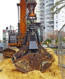 Brottning för två skal En brottning är en hydrauliskt driven jordluckrare med två eller motsättande spakar som klämmer en journal royaltyfri fotografi Brottning för två skal En brottning är en hydrauliskt driven jordluckrare med två eller motsättande spakar som klämmer en journal royaltyfri fotografi