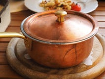 Brown Lidded Cooking Pot on Gray Round Wooden Coaster Royalty Free Stock Images Brown Lidded Cooking Pot on Gray Round Wooden Coaster Royalty Free Stock Images