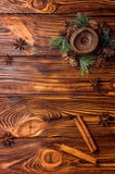 Brown świeczka dekorująca z jedlinową gałąź z małymi rożkami Cynamonowi kije i anyż lokalizują w pobliżu fotografia stock Brown świeczka dekorująca z jedlinową gałąź z małymi rożkami Cynamonowi kije i anyż lokalizują w pobliżu fotografia stock