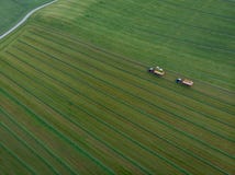 Brummen geschossen vom landwirtschaftlichen Feld mit den Traktoren, die Heu ernten lizenzfreie stockbilder Brummen geschossen vom landwirtschaftlichen Feld mit den Traktoren, die Heu ernten lizenzfreie stockbilder