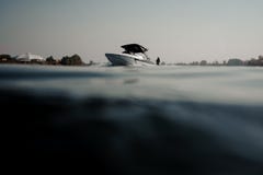 Brunetki dziewczyny jazda na wakeboard trzyma arkanę na motorboat fotografia royalty free Brunetki dziewczyny jazda na wakeboard trzyma arkanę na motorboat fotografia royalty free