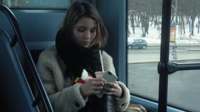 Οι νέοι γύροι γυναικών brunette στις δημόσιες συγκοινωνίες, χρησιμοποιούν το τηλέφωνο με τα ακουστικά απόθεμα βίντεο Οι νέοι γύροι γυναικών brunette στις δημόσιες συγκοινωνίες, χρησιμοποιούν το τηλέφωνο με τα ακουστικά απόθεμα βίντεο