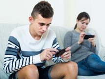 Brunette en tiener die de schermen van smartphones bekijken stock foto Brunette en tiener die de schermen van smartphones bekijken stock foto