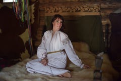 brunette in white linen old-fashioned shirt with embroidery sits on a medieval bed royalty free stock photo brunette in white linen old-fashioned shirt with embroidery sits on a medieval bed royalty free stock photo