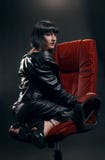 Brunette woman in red armchair stock photo Brunette woman in red armchair stock photo