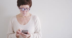 Brunettkvinna i exponeringsglas med telefonen på vit bakgrund Brunettkvinna i exponeringsglas med telefonen på vit bakgrund