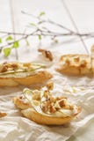 Bruschetta ή crostini με το ricotta, το αχλάδι, τα ξύλα καρυδιάς και το μέλι στοκ φωτογραφία με δικαίωμα ελεύθερης χρήσης Bruschetta ή crostini με το ricotta, το αχλάδι, τα ξύλα καρυδιάς και το μέλι στοκ φωτογραφία με δικαίωμα ελεύθερης χρήσης