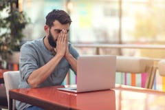Brustbild des erfolgreichen bärtigen Designers, der an der Kamera beim Arbeiten an freiberuflich tätigem am netbook lächelt lizenzfreie stockfotos Brustbild des erfolgreichen bärtigen Designers, der an der Kamera beim Arbeiten an freiberuflich tätigem am netbook lächelt lizenzfreie stockfotos