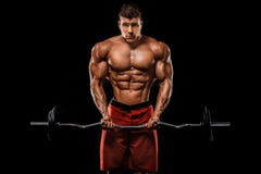 Brutalnego silnego mięśniowego bodybuilder sportowy mężczyzna pompuje w górę mięśni z barbell na czarnym tle trening zdjęcia royalty free Brutalnego silnego mięśniowego bodybuilder sportowy mężczyzna pompuje w górę mięśni z barbell na czarnym tle trening zdjęcia royalty free