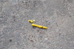 Bruten gul f?rgpenna som ligger p? en smutsig gr? konkret gata arkivfoto Bruten gul f?rgpenna som ligger p? en smutsig gr? konkret gata arkivfoto
