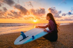Bränningflicka och hav Härlig surfareflicka för ung kvinna med surfingbrädan på en strand på solnedgången eller soluppgång Arkivfoto Bränningflicka och hav Härlig surfareflicka för ung kvinna med surfingbrädan på en strand på solnedgången eller soluppgång Arkivfoto