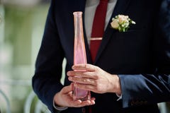 Bräutigam hält Flasche mit rosa Sand an der Hochzeit stockbilder Bräutigam hält Flasche mit rosa Sand an der Hochzeit stockbilder