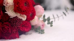 Bröllopbukett av röda och vita blommor på insnöade vintergröna conferous trän Slut och makrosikt av mjuka rosor på Bröllopbukett av röda och vita blommor på insnöade vintergröna conferous trän Slut och makrosikt av mjuka rosor på