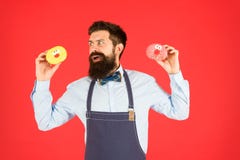 Bu?uelo esmaltado Hombre preparado bien barbudo en el delantal que vende los anillos de espuma Comida del bu?uelo Mercanc?as coci imagen de archivo Bu?uelo esmaltado Hombre preparado bien barbudo en el delantal que vende los anillos de espuma Comida del bu?uelo Mercanc?as coci imagen de archivo
