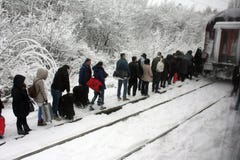 BUCURESTI, άνθρωποι Ρουμανία-cca 2016 σε μια σειρά διασχίστε τις ράγες τραίνων στη ισχυρή χιονόπτωση με τις αποσκευές στα χέρια τ στοκ εικόνες με δικαίωμα ελεύθερης χρήσης BUCURESTI, άνθρωποι Ρουμανία-cca 2016 σε μια σειρά διασχίστε τις ράγες τραίνων στη ισχυρή χιονόπτωση με τις αποσκευές στα χέρια τ στοκ εικόνες με δικαίωμα ελεύθερης χρήσης