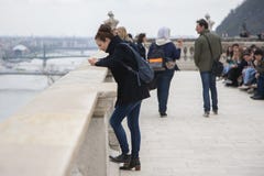 Budapest, Hungary - April 10, 2018: Young women concentrated looks at the mobile phone screen stock image Budapest, Hungary - April 10, 2018: Young women concentrated looks at the mobile phone screen stock image