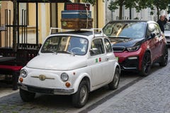 BUDAPEST, HUNGRIA - 5 DE MAIO DE 2018: A autorização 500 do veterano encontra bmw moderno i3 Tecnologia e tradição O passado e o imagem de stock royalty free BUDAPEST, HUNGRIA - 5 DE MAIO DE 2018: A autorização 500 do veterano encontra bmw moderno i3 Tecnologia e tradição O passado e o imagem de stock royalty free