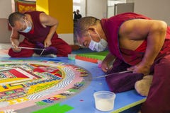 Buddhistische Mönche, die Mandala von farbigem Sand machen lizenzfreies stockbild Buddhistische Mönche, die Mandala von farbigem Sand machen lizenzfreies stockbild