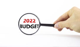 2022 budget new year symbol. Businessman holds magnifying glass with words `2022 budget` on beautiful white background. Business