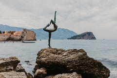 BUDVA, ЧЕРНОГОРИЯ - 5-ое ноября 2018: Красивый вид танцора балерины скульптуры Budva на заходе солнца в Budva стоковое изображение rf BUDVA, ЧЕРНОГОРИЯ - 5-ое ноября 2018: Красивый вид танцора балерины скульптуры Budva на заходе солнца в Budva стоковое изображение rf