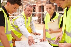 Builder On Building Site Discussing Work With Apprentice Stock Photography Builder On Building Site Discussing Work With Apprentice Stock Photography