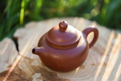 Bule chinês pequeno da argila para a cerimônia de chá na laje de madeira no morni imagem de stock Bule chinês pequeno da argila para a cerimônia de chá na laje de madeira no morni imagem de stock