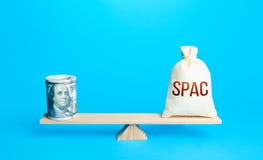 Bundle of dollars and a bag of SPAC on scales. The concept of attracting investors` money to fund the merger of companies into