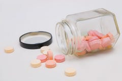 Bunte Antiacidumtabletten, die aus Glasflasche heraus verschüttet werden lizenzfreies stockfoto Bunte Antiacidumtabletten, die aus Glasflasche heraus verschüttet werden lizenzfreies stockfoto