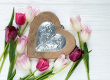 Bunte schöne Tulpen und großes hölzernes Herz auf dem weißen Holztisch Valentinsgrüße, Frühlingshintergrund stockfotografie Bunte schöne Tulpen und großes hölzernes Herz auf dem weißen Holztisch Valentinsgrüße, Frühlingshintergrund stockfotografie