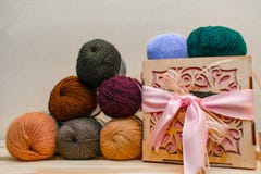 Bunte verschiedene Textilgarn-Fadenbälle Reihe der langen breiten gefalteten Wolle auf dem Tiefenkastenfeld Holzkiste mit Rosa stockbild Bunte verschiedene Textilgarn-Fadenbälle Reihe der langen breiten gefalteten Wolle auf dem Tiefenkastenfeld Holzkiste mit Rosa stockbild