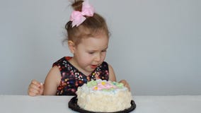 Buon compleanno Una ragazza sveglia del bambino mangia un dolce e lecca il suo dito archivi video Buon compleanno Una ragazza sveglia del bambino mangia un dolce e lecca il suo dito archivi video