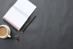 Bureau noir avec la tasse de café, le clavier, le carnet, et le stylo placé dedans photo stock Bureau noir avec la tasse de café, le clavier, le carnet, et le stylo placé dedans photo stock
