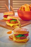 Burger fast food made at home, with meat, lettuce, tomato, cheese, pickles and mayonese on wooden board and table. Copy space. stock image Burger fast food made at home, with meat, lettuce, tomato, cheese, pickles and mayonese on wooden board and table. Copy space. stock image