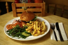 Burger In A Brioche Bun With Chips & Side Salad Royalty Free Stock Image