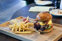 Burger with lettuce and bacon and french fries on the newspaper royalty free stock image Burger with lettuce and bacon and french fries on the newspaper royalty free stock image