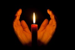 A burning candle at night, surrounded by the hands of a woman. Symbol of life, love and light, protection and warmth. stock photos A burning candle at night, surrounded by the hands of a woman. Symbol of life, love and light, protection and warmth. stock photos