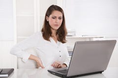 Burnout: müde Geschäftsfrau, die am Laptop - Rückenschmerzen die Stirn runzelt oder lizenzfreie stockfotografie Burnout: müde Geschäftsfrau, die am Laptop - Rückenschmerzen die Stirn runzelt oder lizenzfreie stockfotografie