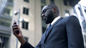 Business application, serious afro-american businessman working on smartphone royalty free stock photography Business application, serious afro-american businessman working on smartphone royalty free stock photography