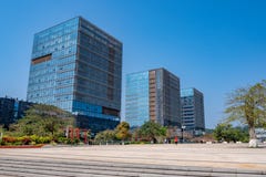 Business buildings with glass exterior and plaza with trees on blue sky background stock photos Business buildings with glass exterior and plaza with trees on blue sky background stock photos