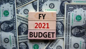 Business concept of budget planning 2021. Wooden blocks with the words `FY 2021 budget`. Beautiful background from dollar bills,